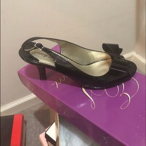 Black patent leather slip on with bow accent.